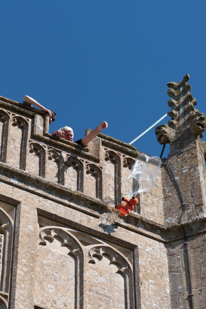 teddy bear parachuting from the Church tower in Burton, Wiltshire